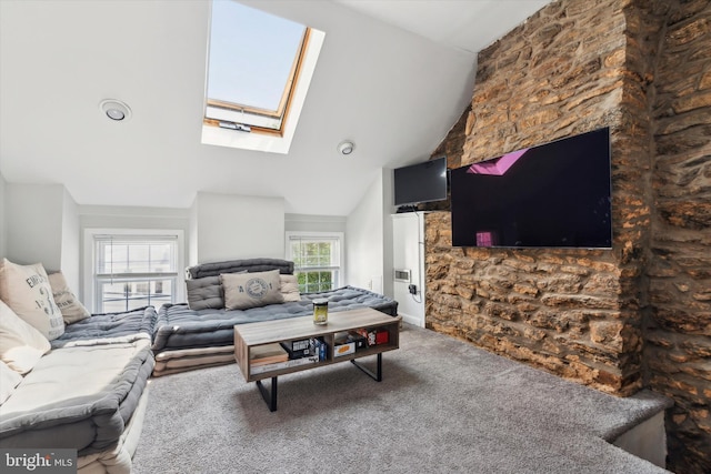 living room with high vaulted ceiling, a healthy amount of sunlight, carpet, and a skylight