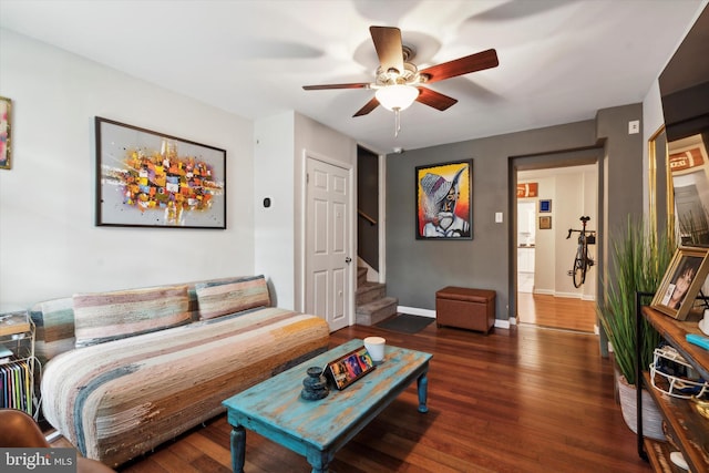 living room with ceiling fan and dark hardwood / wood-style flooring