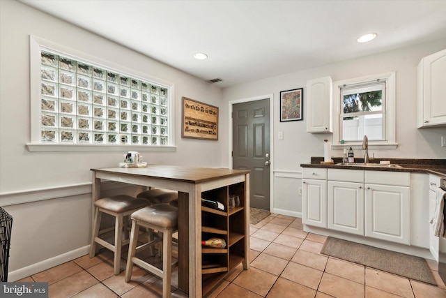 kitchen with sink, white cabinetry, and light tile patterned flooring