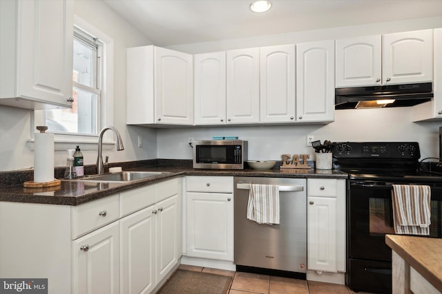 kitchen with sink, appliances with stainless steel finishes, white cabinetry, and light tile patterned floors