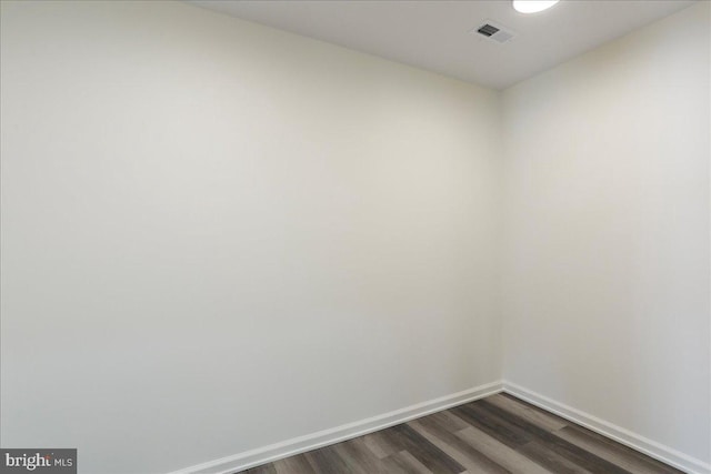 unfurnished room featuring dark wood-type flooring