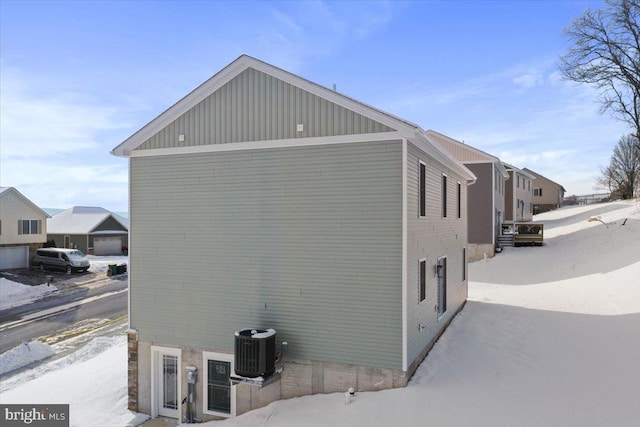 snow covered property with cooling unit