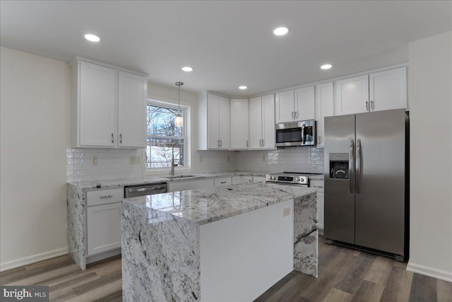 kitchen with white cabinetry, a kitchen island, decorative light fixtures, stainless steel appliances, and dark hardwood / wood-style floors