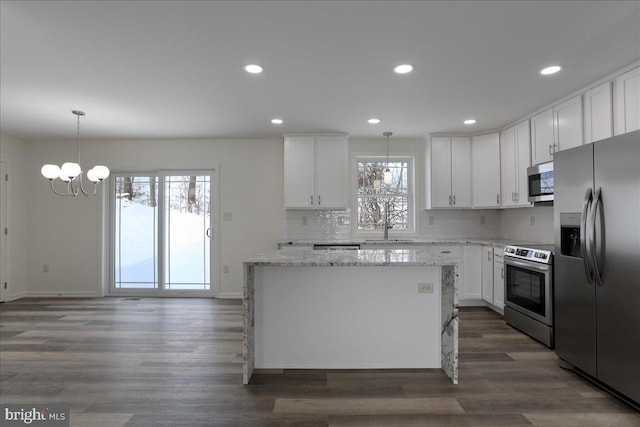 kitchen featuring white cabinetry, hanging light fixtures, appliances with stainless steel finishes, and a healthy amount of sunlight