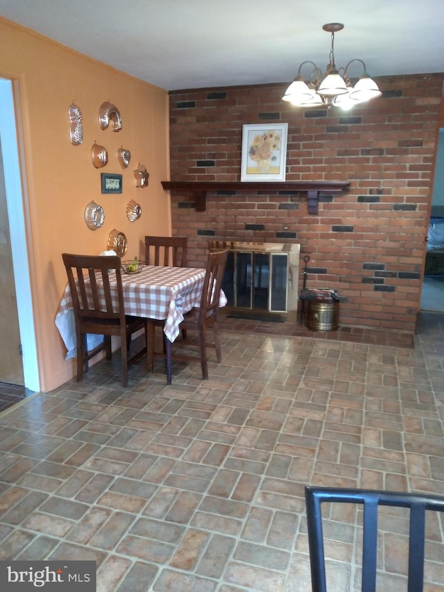 dining room featuring an inviting chandelier and a fireplace