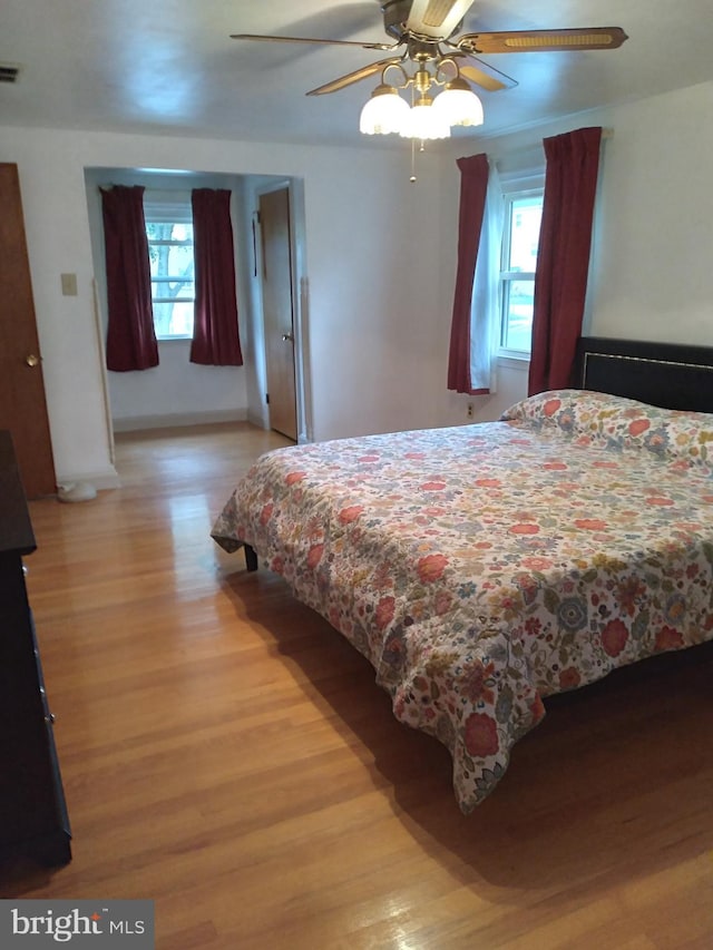 bedroom featuring multiple windows, light wood-type flooring, and ceiling fan