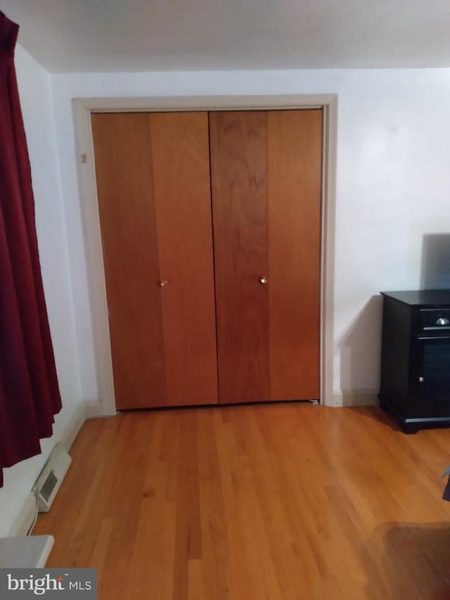 unfurnished bedroom with light hardwood / wood-style flooring and a closet