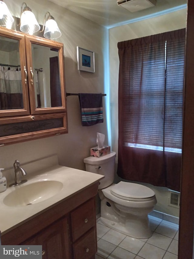 bathroom with vanity, toilet, and tile patterned floors