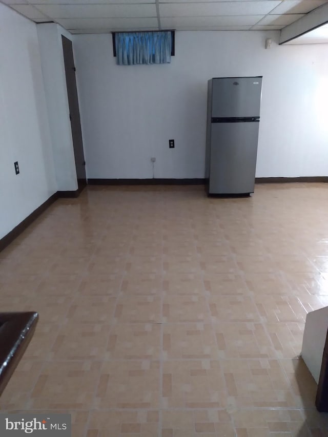 spare room with light tile patterned floors and a drop ceiling