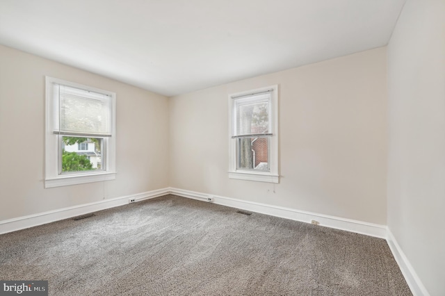 unfurnished room featuring carpet flooring and plenty of natural light