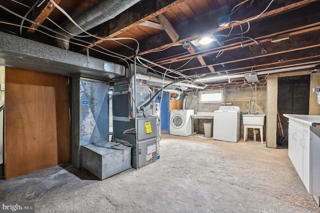 basement featuring washing machine and clothes dryer and sink