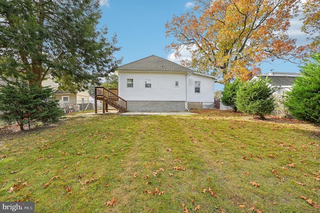 rear view of property with a patio and a lawn