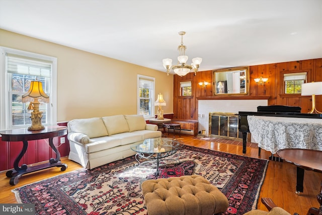 living room featuring a notable chandelier, wood-type flooring, and a wealth of natural light