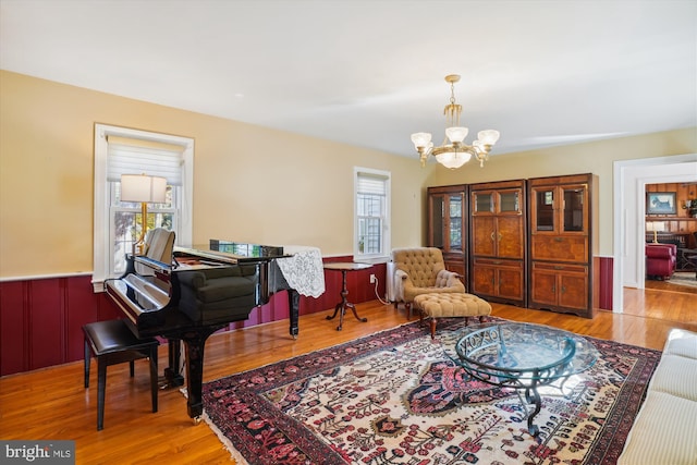 sitting room featuring a chandelier, light wood-type flooring, and a healthy amount of sunlight