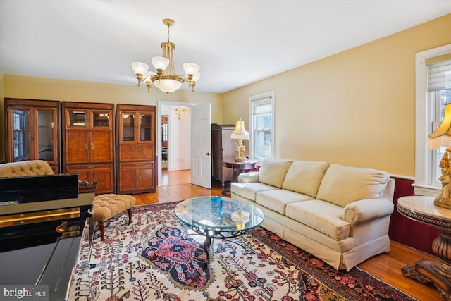 living room with light hardwood / wood-style floors and an inviting chandelier