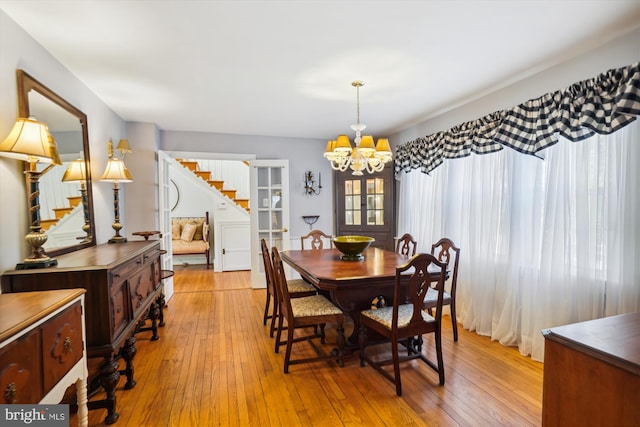 dining area featuring light hardwood / wood-style flooring and a notable chandelier