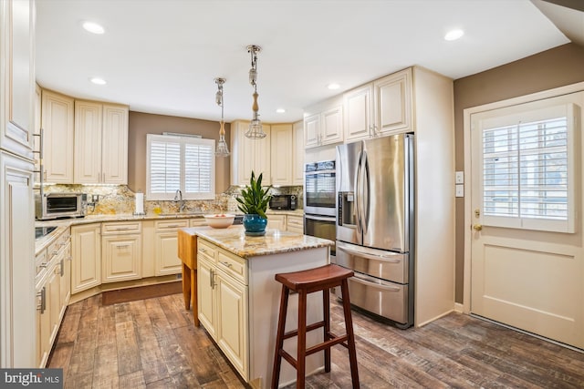 kitchen with decorative backsplash, stainless steel appliances, dark wood-type flooring, pendant lighting, and a center island