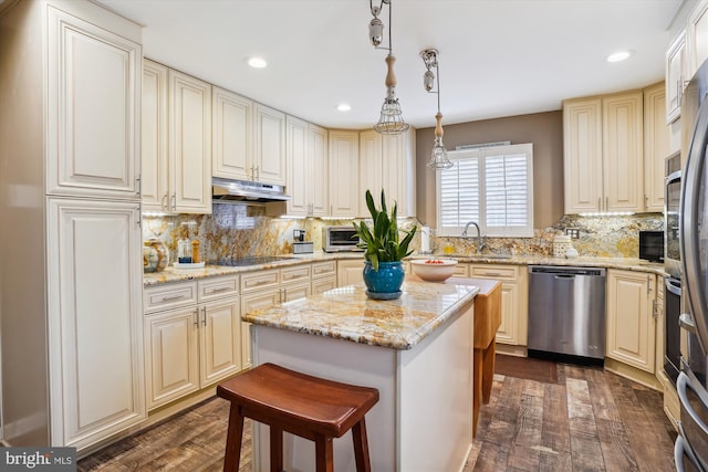 kitchen with dark wood-type flooring, pendant lighting, a kitchen island, and stainless steel appliances