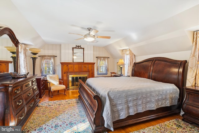 bedroom with light hardwood / wood-style floors, multiple windows, and vaulted ceiling