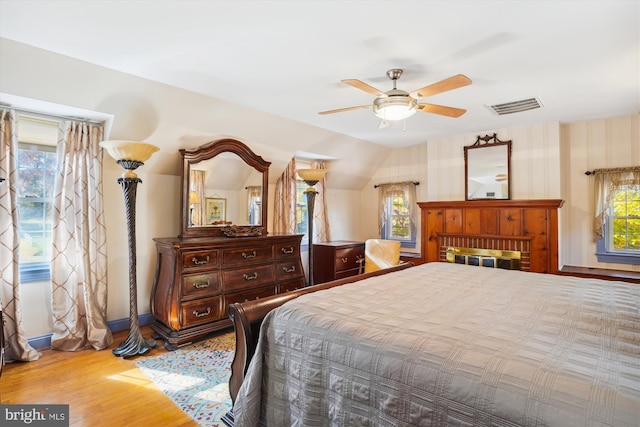 bedroom with ceiling fan, wood-type flooring, and vaulted ceiling