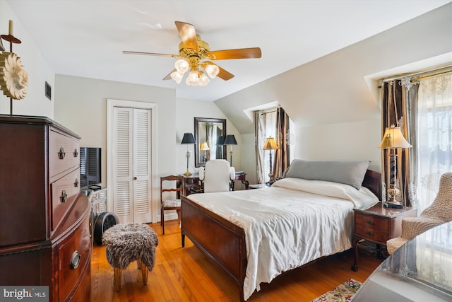 bedroom with ceiling fan, wood-type flooring, and vaulted ceiling