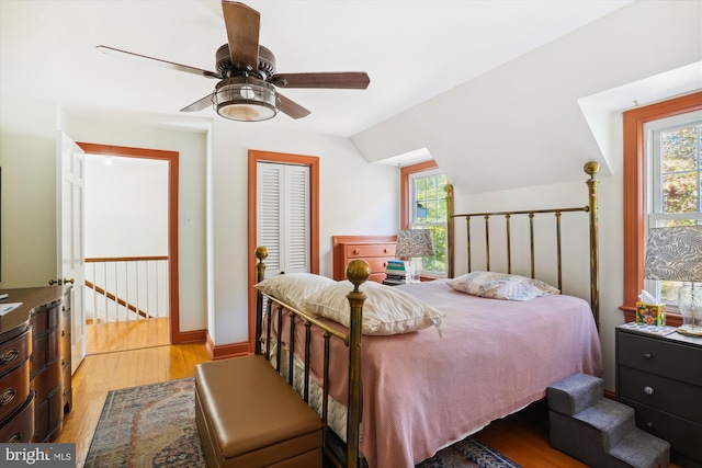 bedroom with ceiling fan, vaulted ceiling, light hardwood / wood-style flooring, and multiple windows