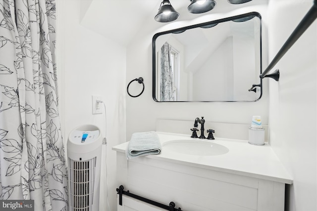 bathroom featuring vanity and lofted ceiling