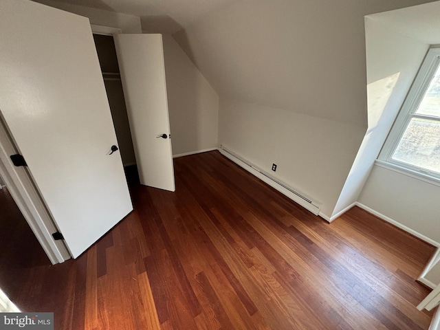 bonus room with a baseboard radiator, dark hardwood / wood-style floors, and lofted ceiling