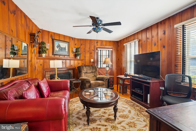 living room featuring a fireplace, ceiling fan, plenty of natural light, and hardwood / wood-style flooring