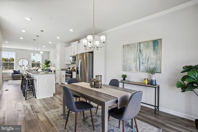 dining space featuring hardwood / wood-style floors and crown molding