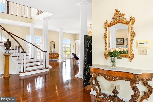 foyer featuring ornate columns and dark hardwood / wood-style floors