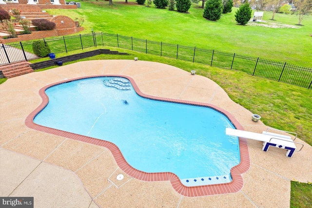 view of pool featuring a yard, a diving board, and a patio area