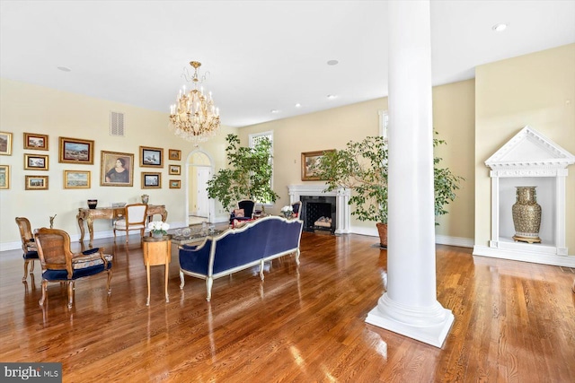 interior space with hardwood / wood-style floors, a notable chandelier, and ornate columns