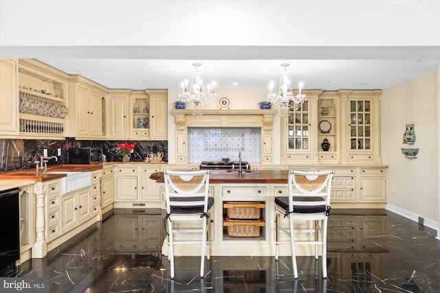 kitchen featuring a notable chandelier, tasteful backsplash, hanging light fixtures, and a breakfast bar area