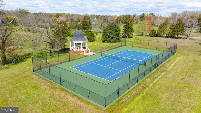 view of tennis court featuring a lawn