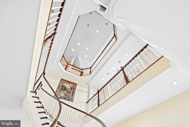 staircase featuring a towering ceiling