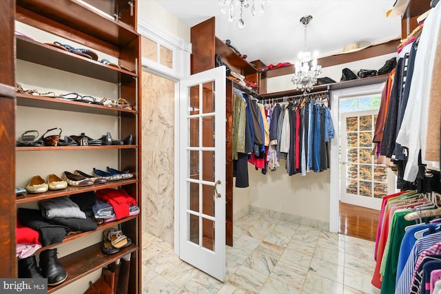 walk in closet featuring a notable chandelier