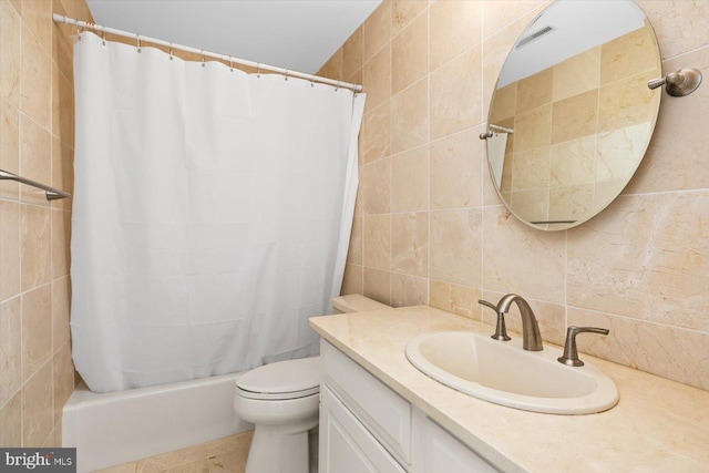 full bathroom with tile walls, vanity, shower / tub combo with curtain, and toilet