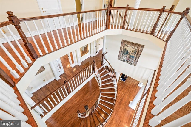 stairway with a high ceiling and wood-type flooring