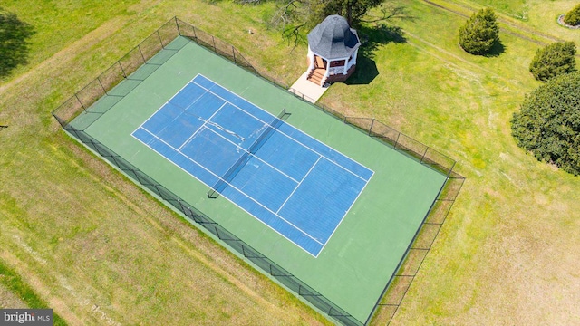 view of tennis court with a lawn