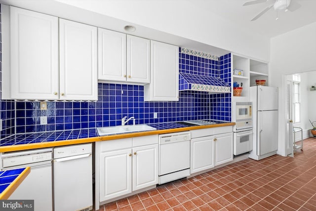 kitchen featuring sink, tasteful backsplash, white cabinets, white appliances, and ceiling fan