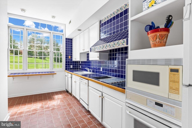 kitchen featuring white appliances, white cabinetry, tile patterned flooring, and decorative backsplash