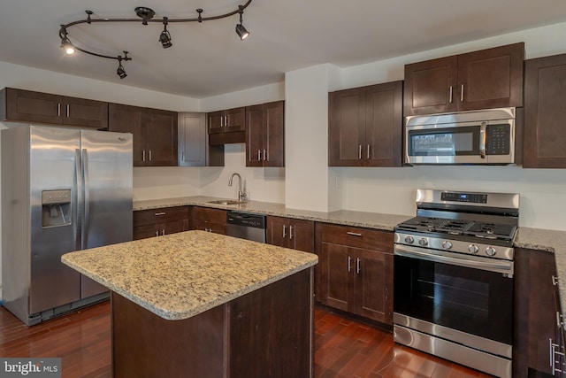 kitchen featuring light stone counters, a kitchen island, dark hardwood / wood-style flooring, and stainless steel appliances