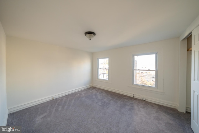 unfurnished room with dark carpet