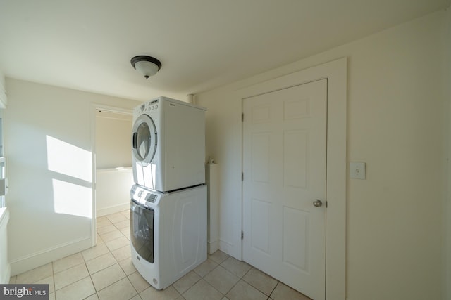 clothes washing area with stacked washer / dryer and light tile patterned flooring