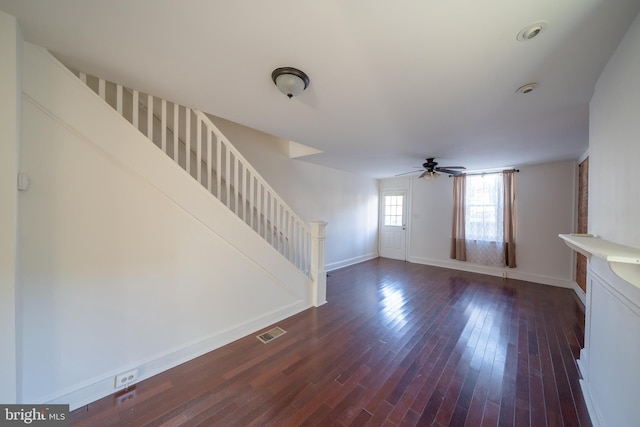 unfurnished living room with dark hardwood / wood-style flooring and ceiling fan