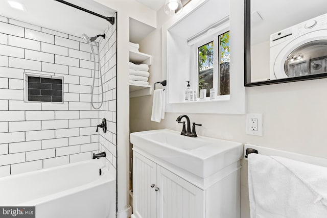 bathroom with vanity, washer / dryer, and tiled shower / bath