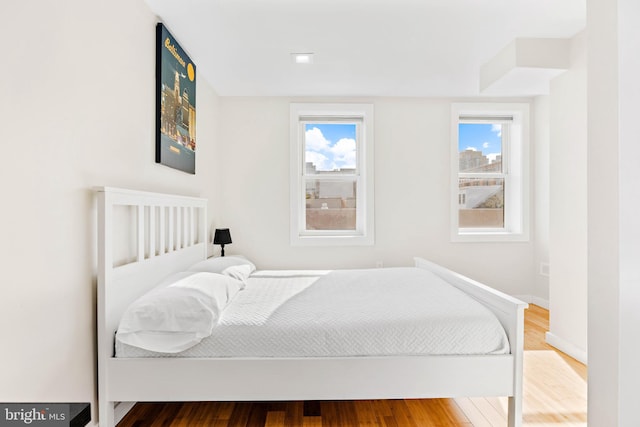 bedroom featuring hardwood / wood-style floors and multiple windows