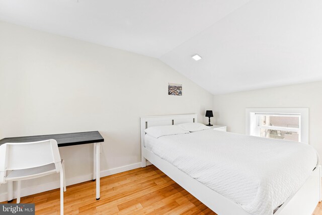 bedroom featuring hardwood / wood-style floors and lofted ceiling