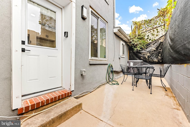 view of exterior entry with a patio area